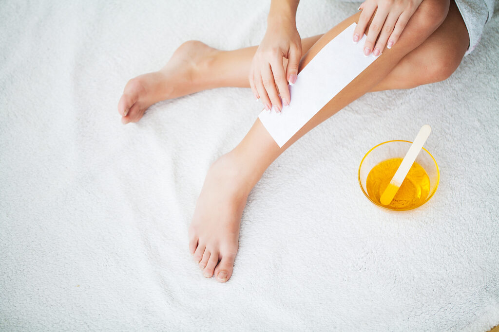 Waxing. Beautician Waxing Woman's Leg In Spa