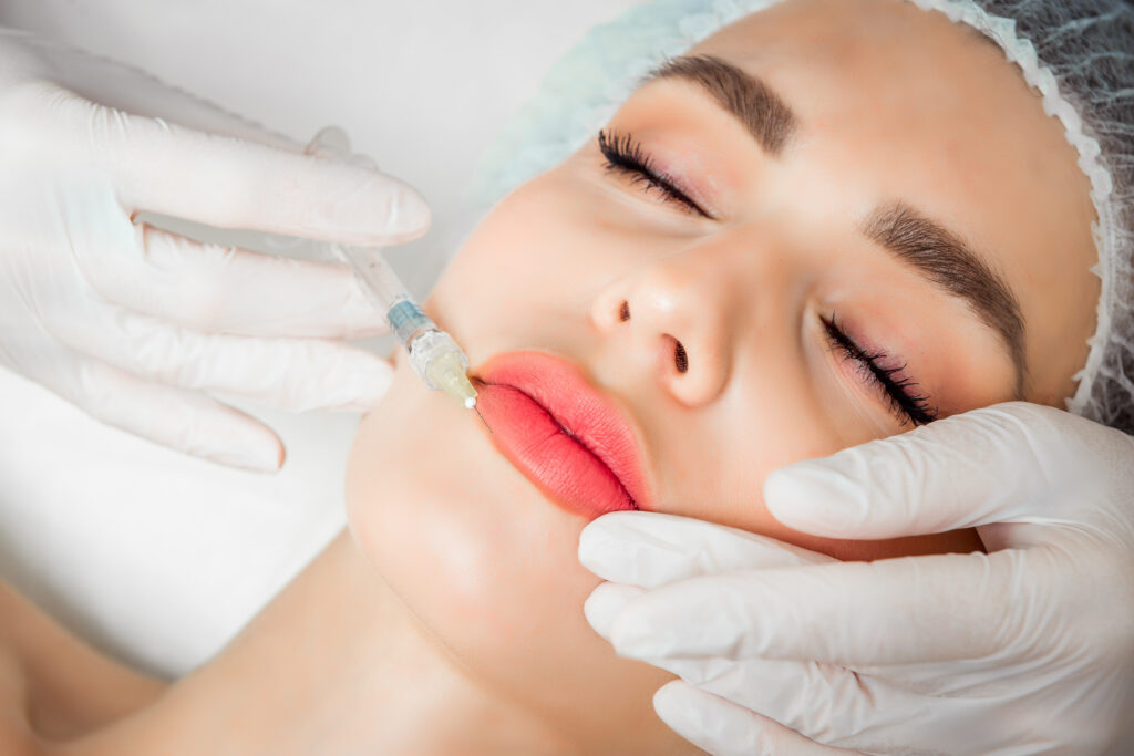 The doctor cosmetologist makes the Rejuvenating facial injections procedure for tightening and smoothing wrinkles on the face skin of a beautiful, young woman in a beauty salon